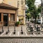 Patinetes e bicicletas elétricas de aluguel enfileirados em vagas numeradas na calçada