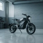 Moto elétrica sozinha em box de oficina com porta de enrolar fechada ao fundo