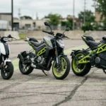 Três motos elétricas de tamanhos diferentes estacionadas lado a lado para comparação